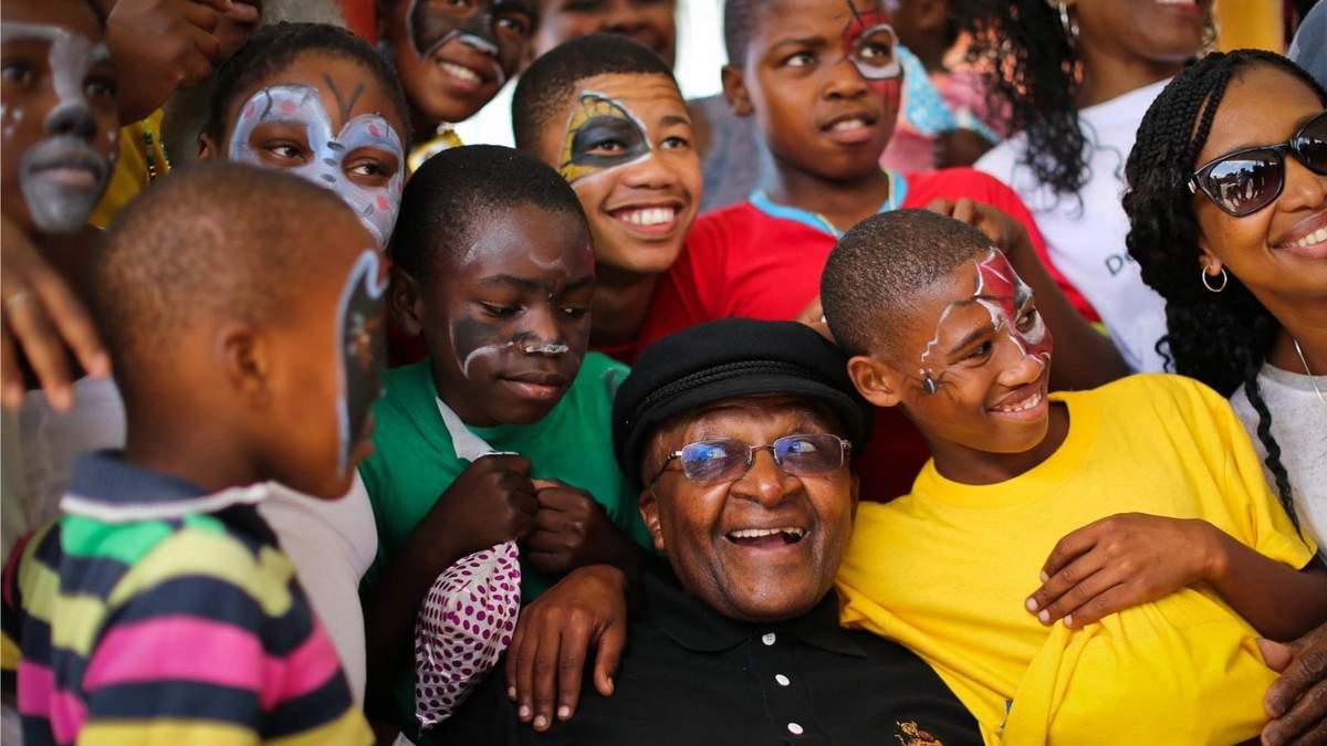 El arzobispo sudafricano, Desmond Tutu rodeado de niños