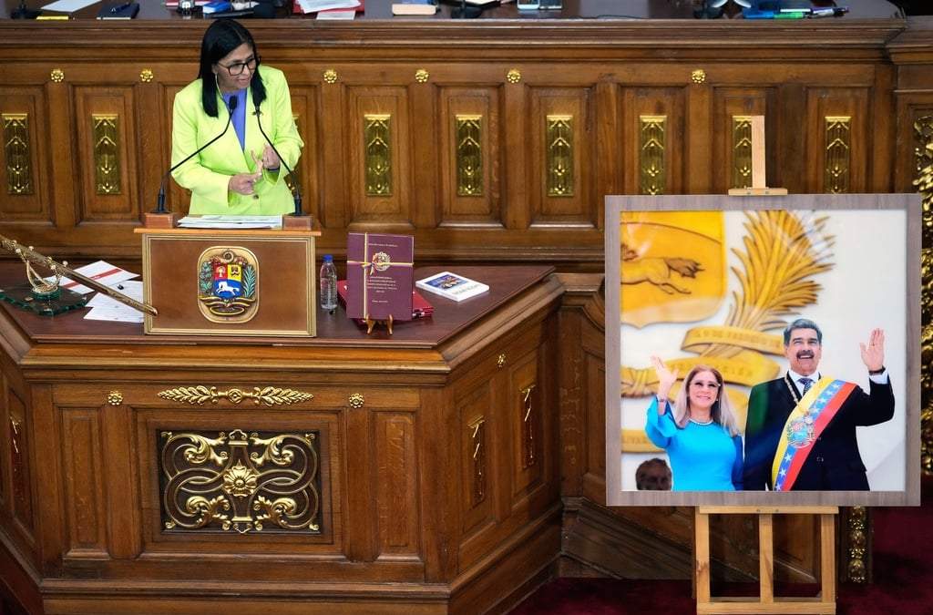 La presidenta encargada de Venezuela, Delcy Rodríguez, habla ante los legisladores junto a una foto del expresidente Nicolás Maduro y su esposa Cilia Flores, en la Asamblea Nacional, el jueves 15 de enero de 2026, en Caracas, Venezuela