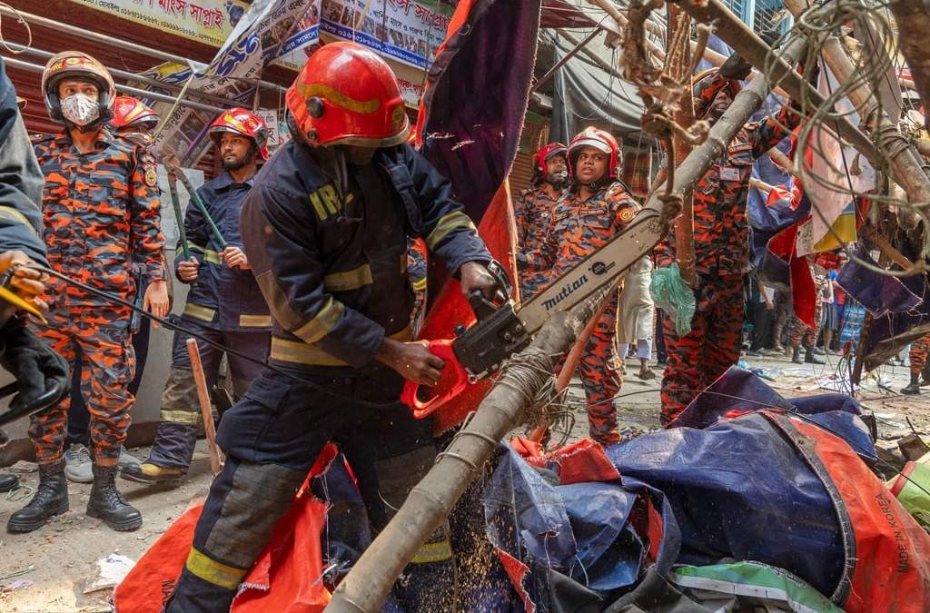 Rescatistas y bomberos cortan andamios que cayeron tras un sismo, en Daca, Bangladesh, el 21 de noviembre de 2025