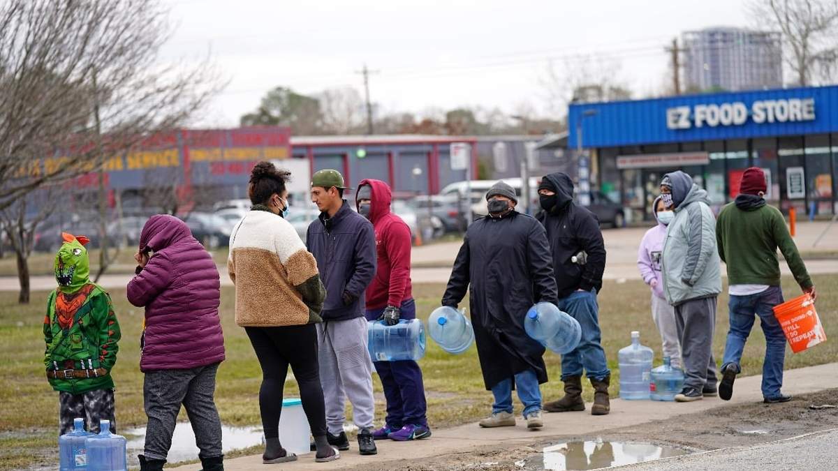 La gente espera a temperaturas a punto de congelación para llenar contenedores con agua del grifo, en Houston