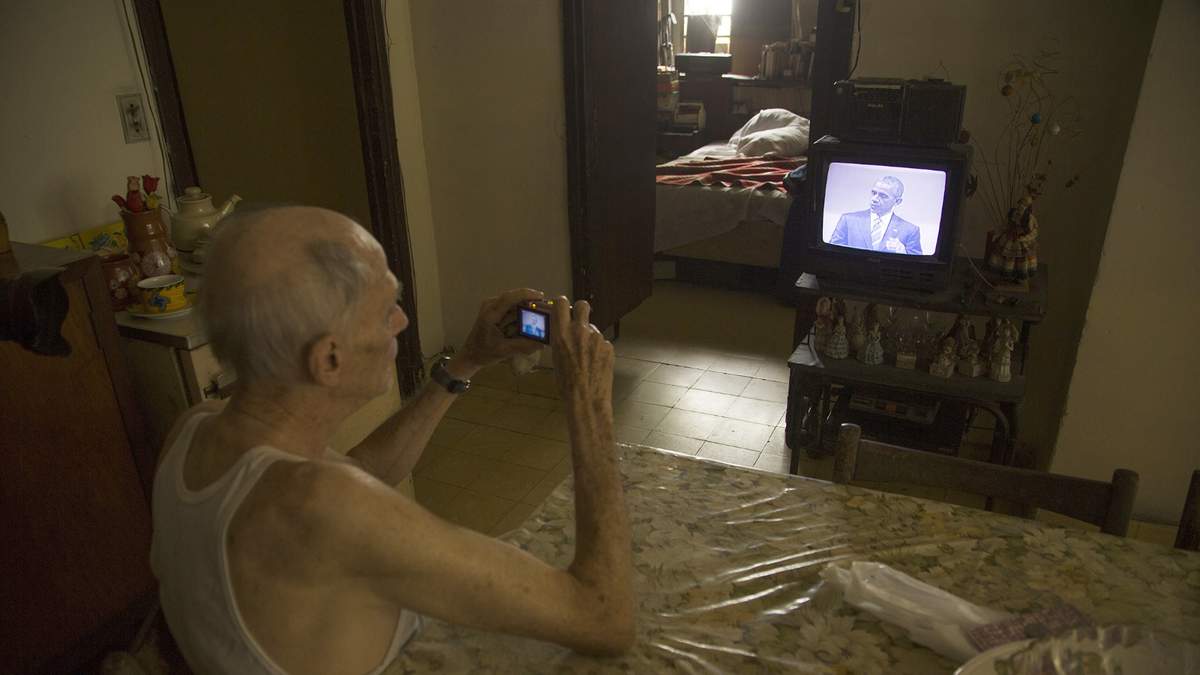 Una hombre mayor observa en su televisión los eventos de Barack Obama en su segundo dia de actividades en La Habana, Cuba