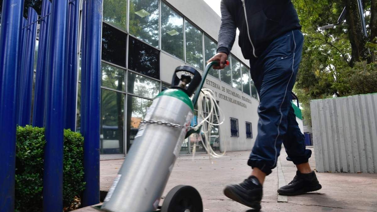 Un tanque de oxigeno es transportado afuera de un hospital en la Ciudad de México