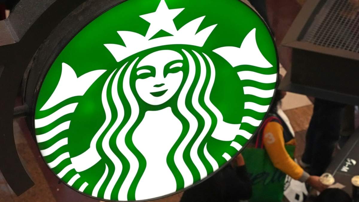 El logotipo de Starbucks en la fila de clientes del Black Friday en un quiosco de Starbucks en la Walden Galleria en Buffalo, Nueva York