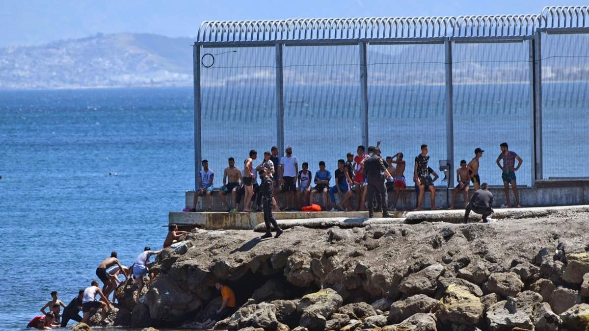Agentes de la Guardia Civil española intentan evitar que personas de Marruecos ingresen a su territorio