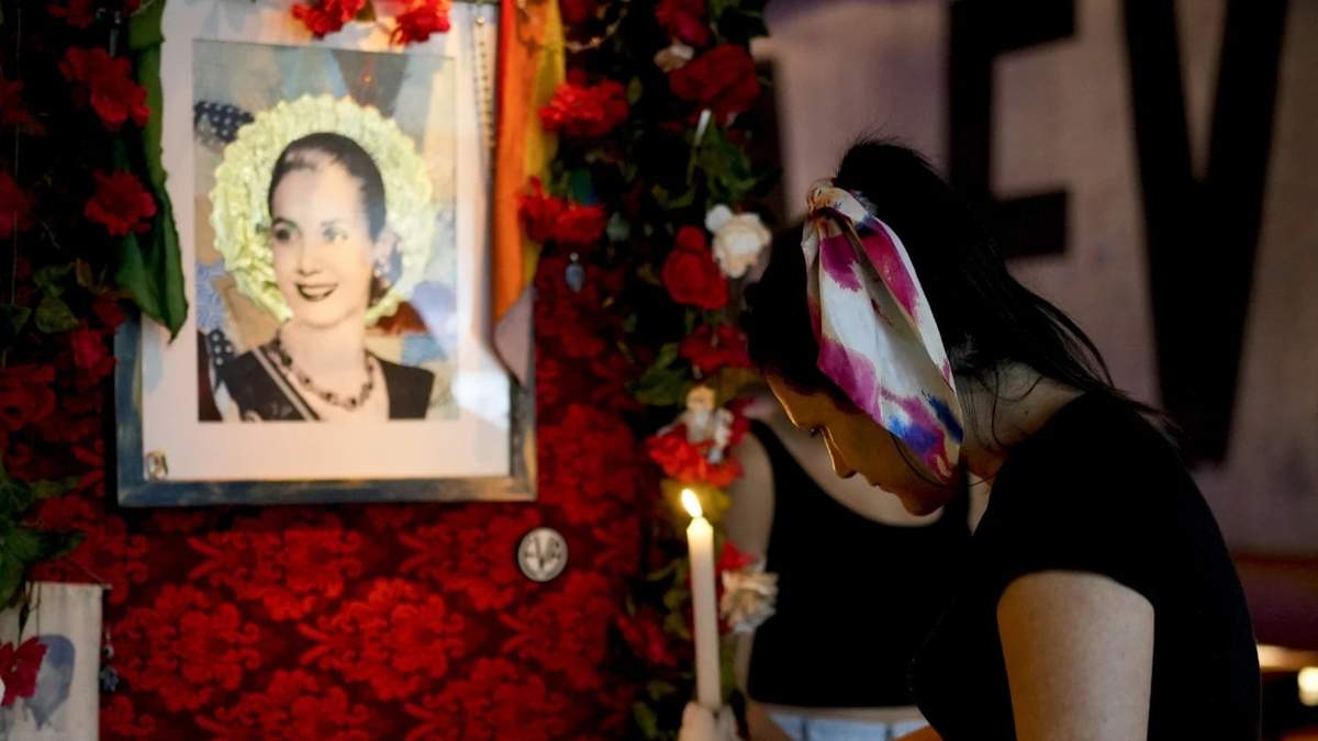 Una camarera enciende una vela en un altar dedicado a la ex primera dama argentina Eva Perón