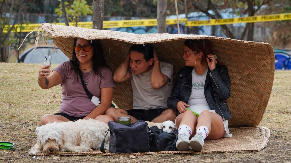 Jóvenes se cubren de la lluvia este domingo durante el Festival "Primavera en Chapultepec 2025" en parque Parcur, primera sección de Chapultepec