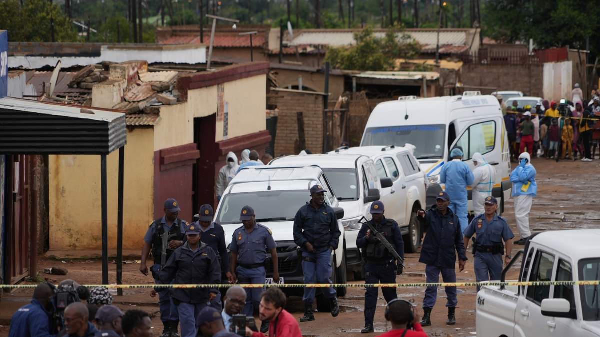 Policías sudafricanos se reúnen en el lugar de un tiroteo masivo donde hombres armados mataron a nueve personas e hirieron al menos a 10 en un pub en Bekkersdal, Sudáfrica