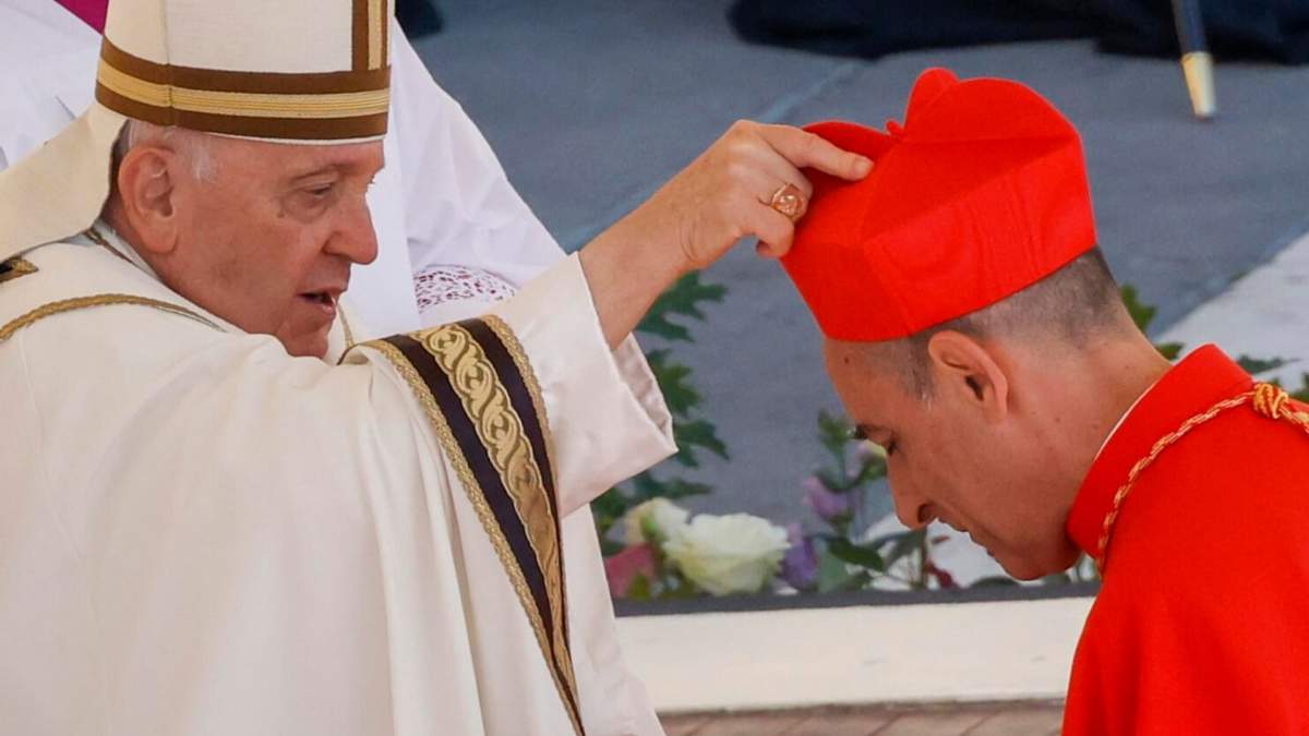 El recién elegido cardenal Víctor Manuel Fernández, prefecto del Dicasterio para la Doctrina de la Fe, a la derecha, recibe su birrete de manos del Papa Francisco mientras es investido en la Plaza de San Pedro del Vaticano
