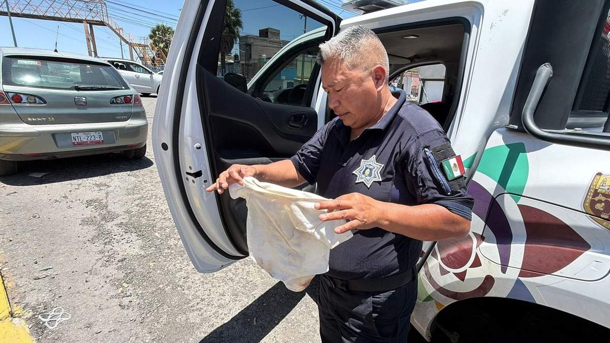 Policía sostiene la prenda sucia en la que se encontraba un bebé que fue abandonado en un taxi de aplicación en Ecatepec, Estado de México