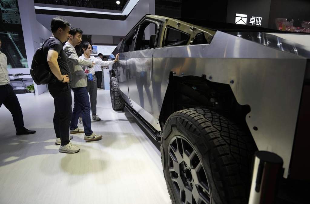 Visitantes miran una versión básica del Cybertruck de Tesla con dispositivos de AOD Technology, que fabrica unidades de control de dominio que procesan diversos comandos como abrir puertas y controlar estribos en SUV, exhibida en la feria automotriz de Shanghái el jueves 24 de abril de 2025