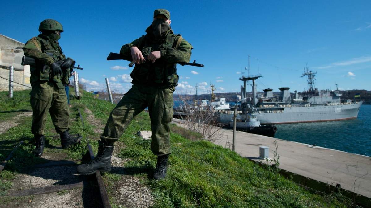 Soldados rusos montan guardia en un muelle en que dos embarcaciones navales ucranianas se encuentran atracadas, en Sebastopol, en la península de Crimea