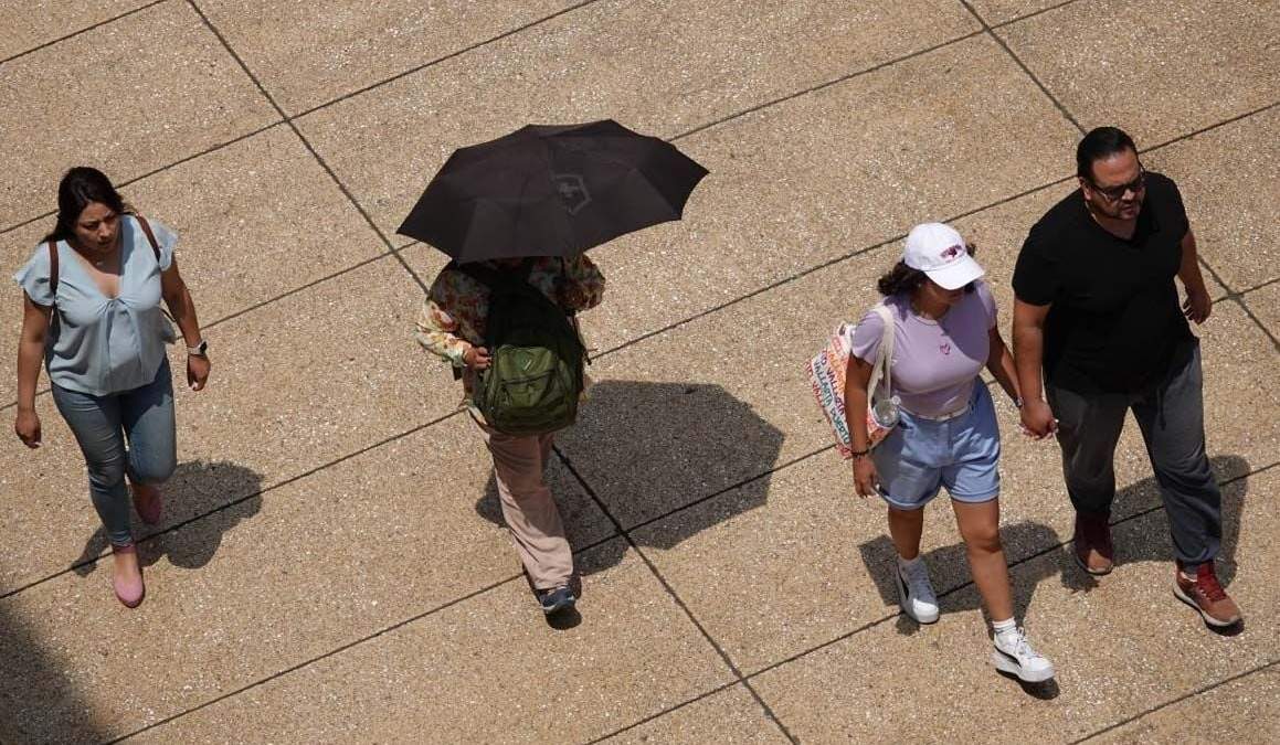 Capitalinos se cubren de los fuertes rayos del sol en el Centro Histórico