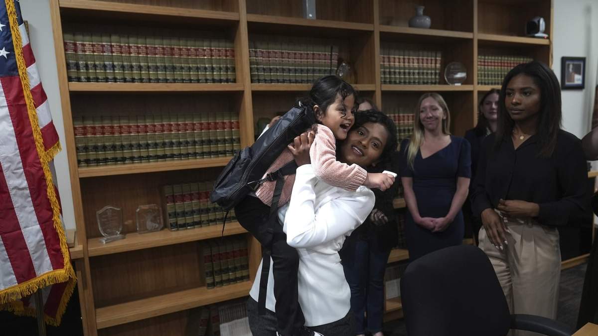 Deysi Vargas carga a su hija de 4 años, que padece síndrome de intestino corto, en una conferencia de prensa en Los Ángeles, el miércoles 28 de mayo de 2025, después de que se les canceló su permiso condicional humanitario