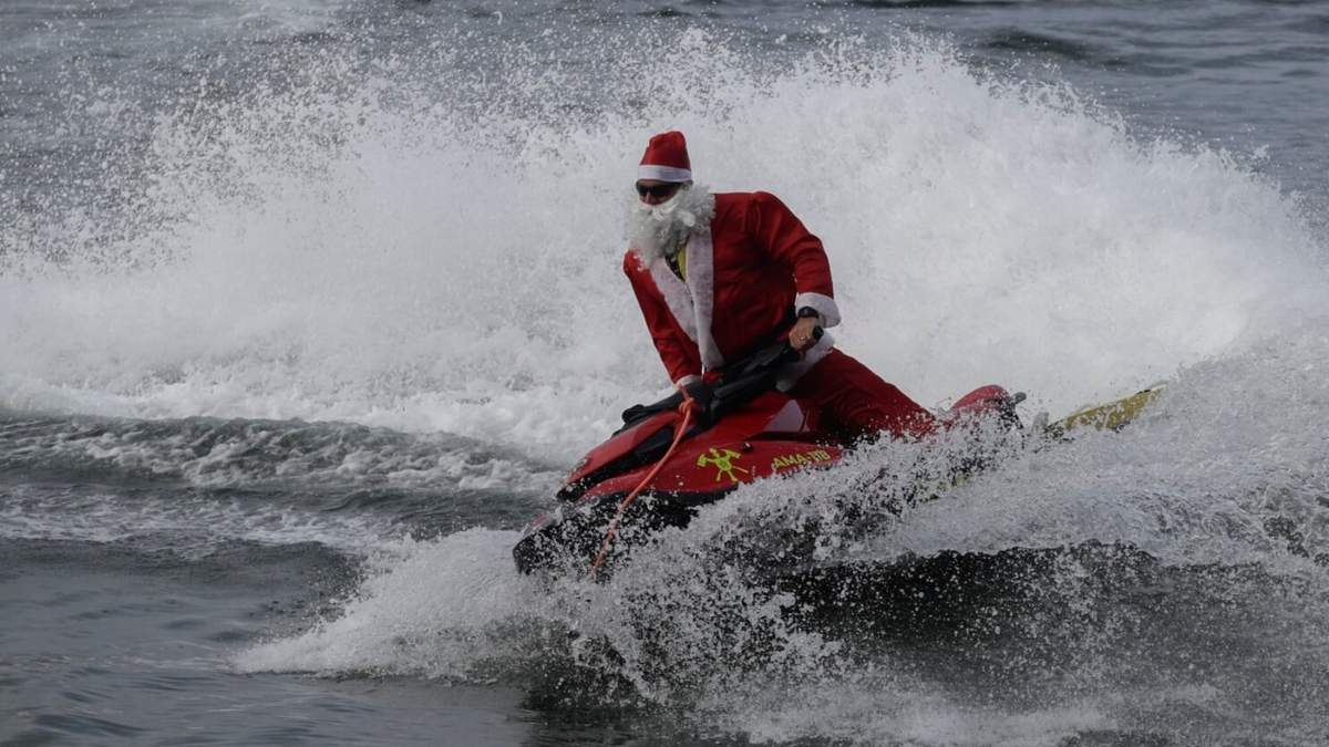 Un bombero disfrazado de Santa Claus en un jet ski por la playa de Copacabana, el martes 17 de diciembre de 2024, en Río de Janeiro