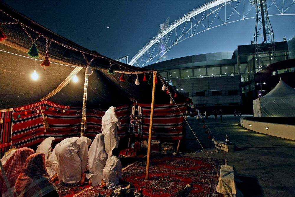 Qataríes rezan en una tienda beduina antes de la ceremonia de inauguración de la Copa de Asia, afuera del estadio Khalifa, en Doha, Qatar, el 7 de enero de 2011