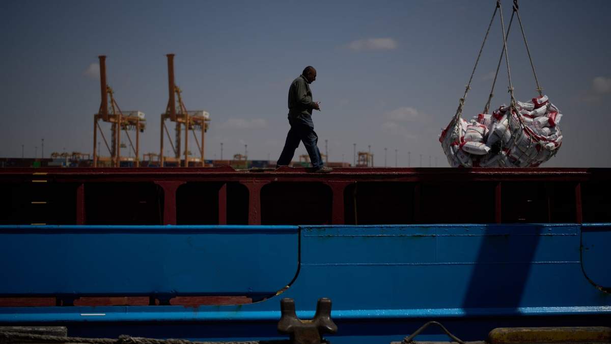 Un trabajador camina por el muelle de un barco mientras trabaja para descargar un cargamento de arroz en el puerto de Umm Qasr, en Irak, el viernes 27 de marzo de 2026