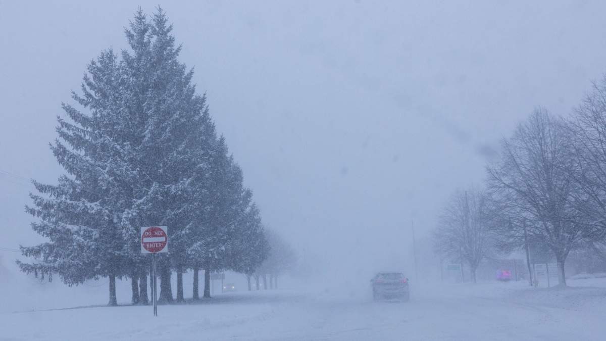 Varios vehículos transitan a lo largo de Lake Michigan Drive durante una advertencia de tormenta de nieve en el condado Ottawa, Michigan