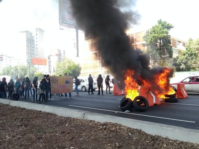 Encapuchados queman llantas y bloquean carril central de Periférico sur a la altura de la ENAH