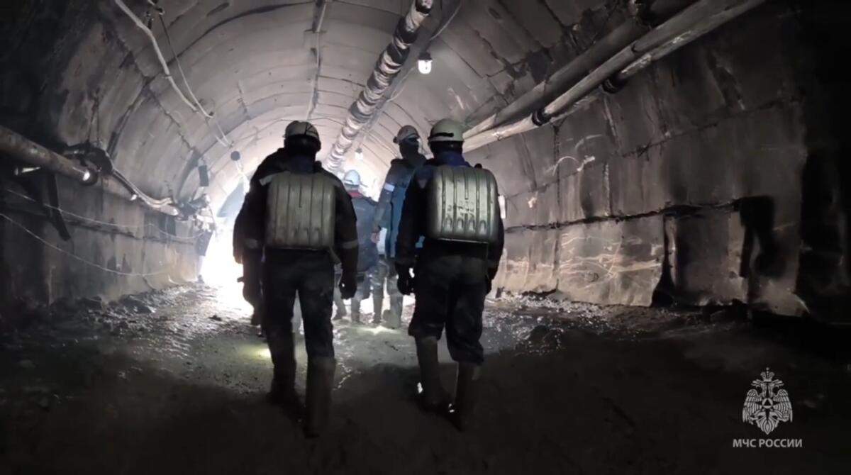 En esta imagen tomada de un video publicado por el servicio de prensa del Ministerio ruso de Situaciones de Emergencia el 25 de marzo de 2024, trabajadores del ministerio caminan a una mina de oro en el distrito de Zeysk, en la región de Amur