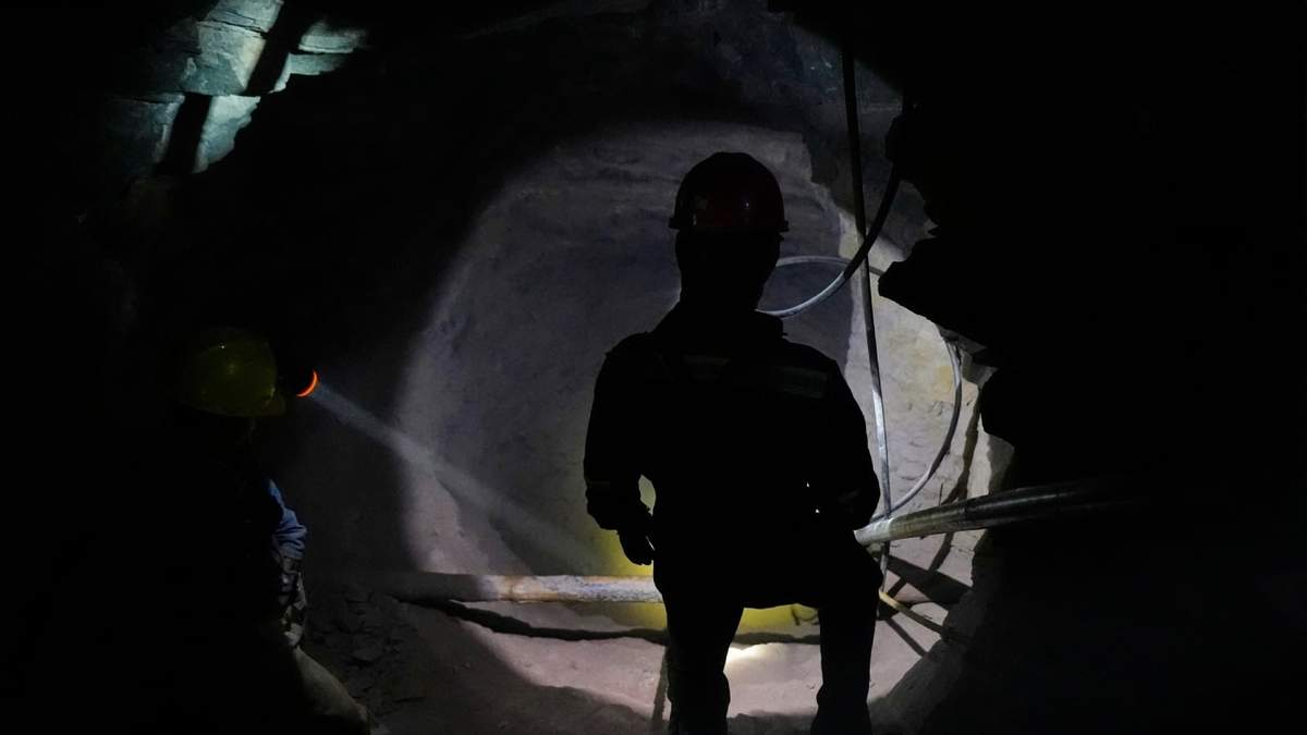 Un minero ilumina una de las cavernas para que sus compañeros puedan ver la salida, en San Joaquín, México, el martes 19 de agosto de 2025