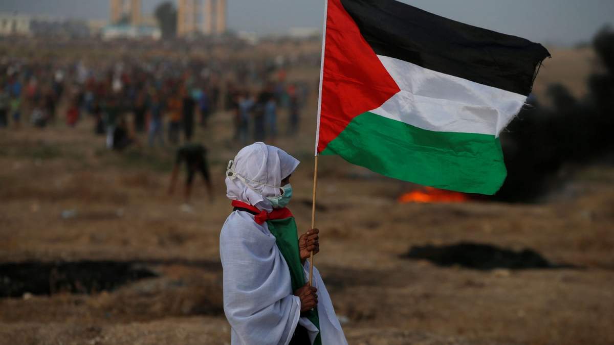 Una mujer palestina sostiene su bandera en medio de las protestas en Gaza. Fuente: (Twitter)