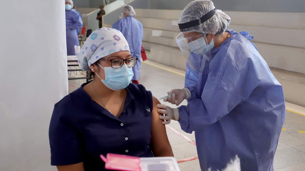 Una trabajadora sanitaria recibe una dosis de la vacuna contra el coronavirus. Fuente: (Twitter)