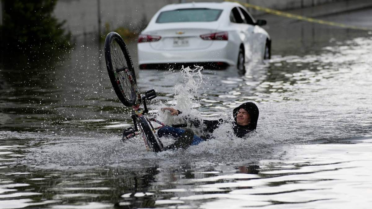 Un ciclista cae mientras intenta atravesar una calle inundada en Las Vegas