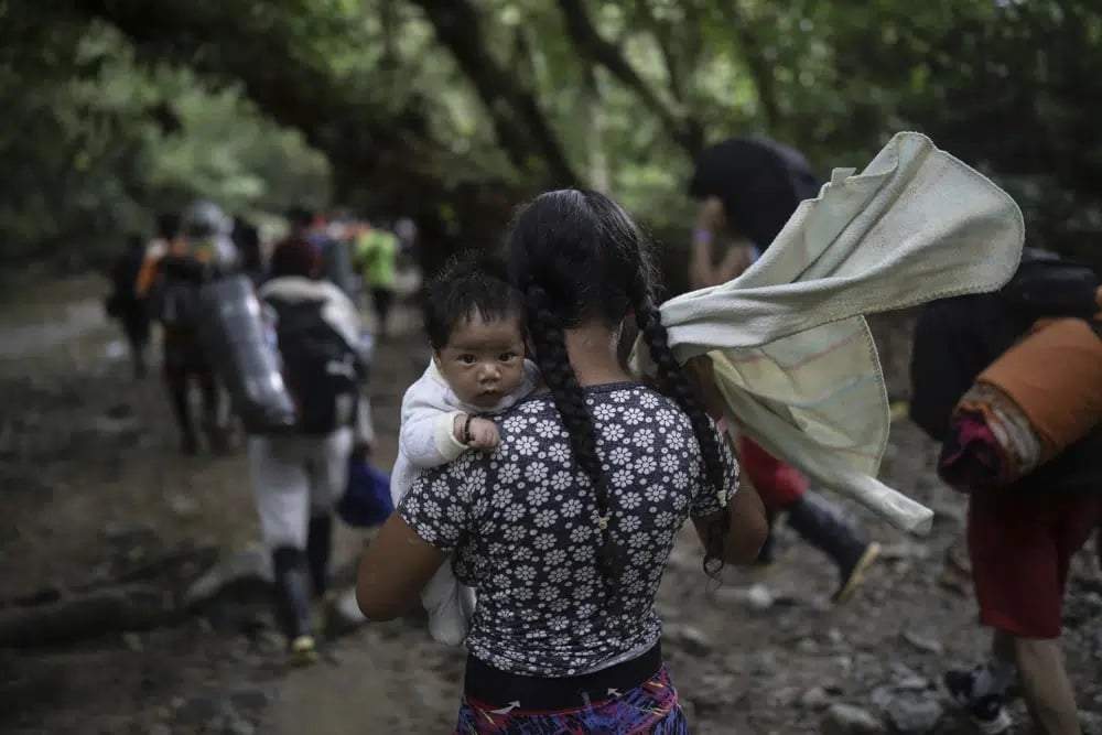 Una migrante boliviana carga un bebé mientras cruza el Tapón del Darién, de Colombia a Panamá, con la esperanza final de llegar a Estados Unidos, el 9 de mayo de 2023