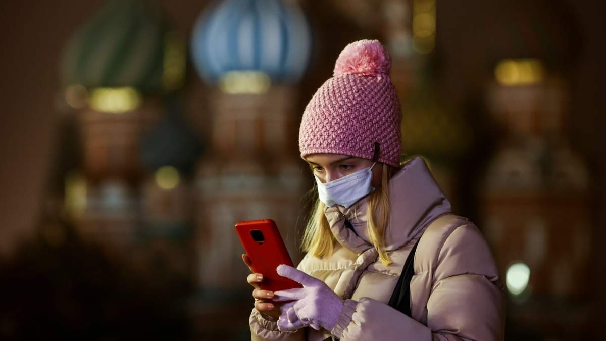 Una mujer sostiene su teléfono frente a la sede del Kremlin, Rusia. Fuente: (Twitter)