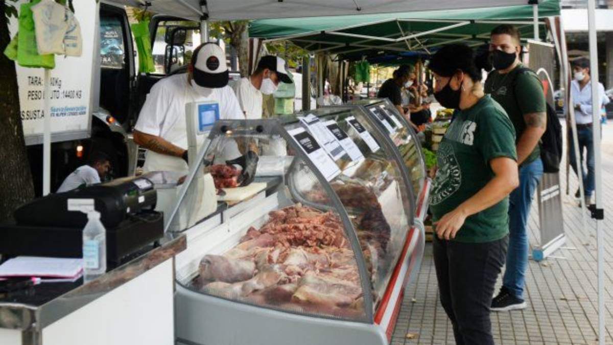Un comerciante y una compradora durante la feria popular del "pescadazo". Fuente: (Twitter)