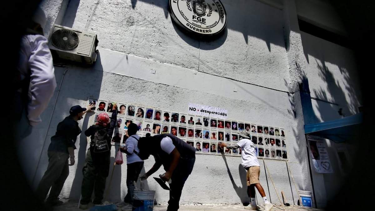 Colectivos y activistas colocan un mural con los rostros de desaparecidos en la Fiscalía General del Estado de Guerrero, para iniciar su jornada de búsqueda y protestas en el marco del Día Internacional de Víctimas de Desaparición Forzada, el 6 de agosto de 2025
