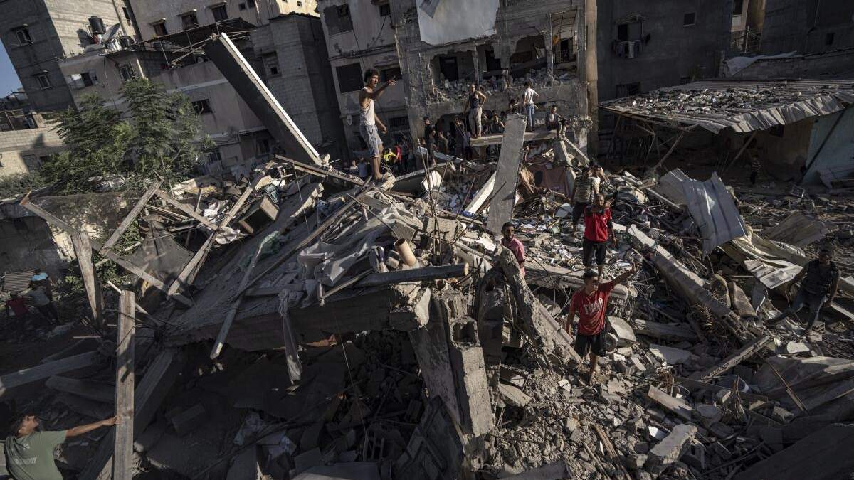 Palestinos miran a la destrucción después de ataques israelíes contra la Franja de Gaza, en Jan Yunis