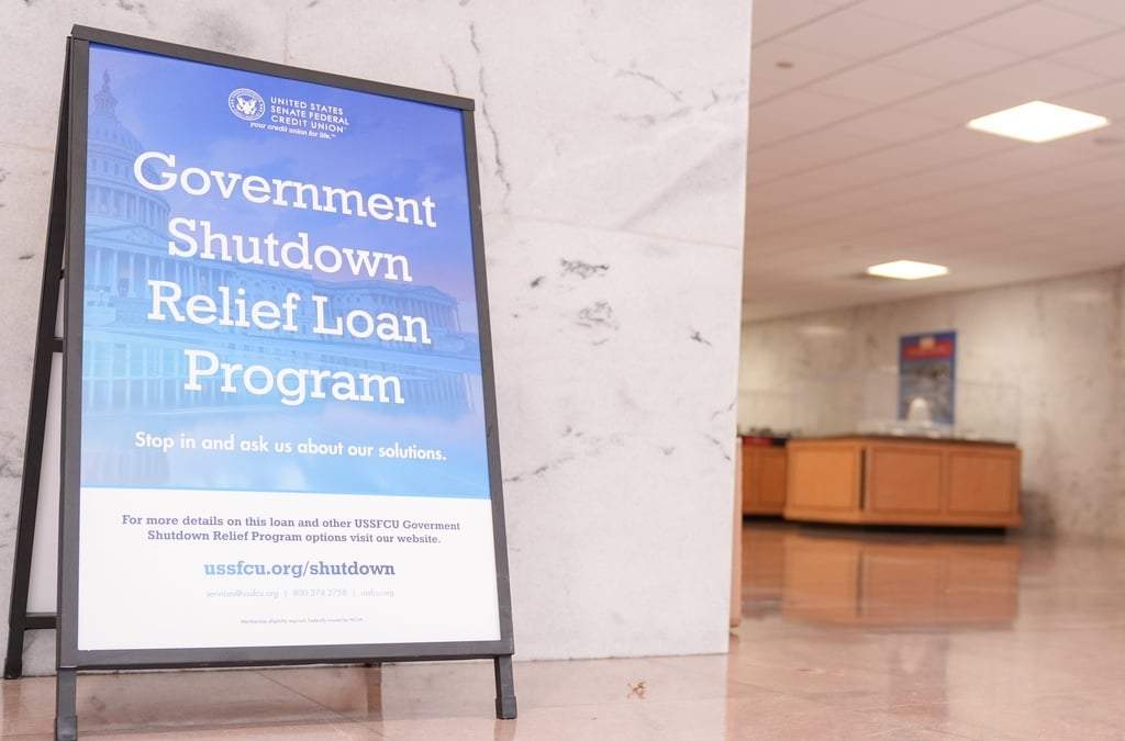 Un cartel con información sobre el Programa de Préstamos para el Alivio del Cierre Gubernamental se ve en el pasillo del Edificio Hart del Senado, el jueves 2 de octubre de 2025, en Washington