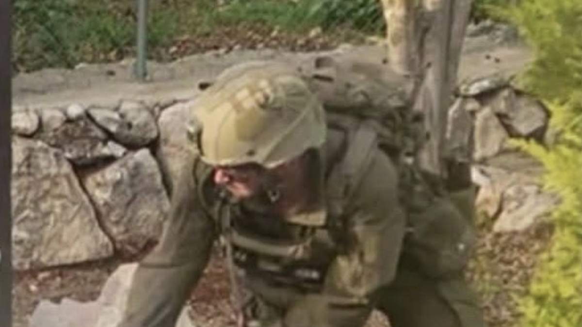 Fragmento de la imagen en la que se ve a un soldado israelí mientras golpea con un mazo la cara de una figura de Jesucristo en el sur de Líbano