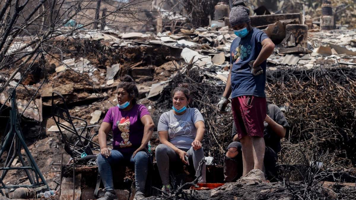 Personas  limpian los escombros de las casas quemadas después de que los incendios forestales alcanzaran su vecindario en Viña del Mar