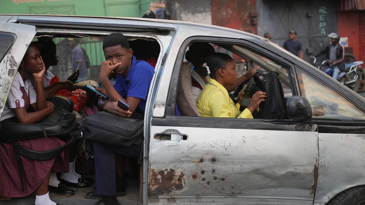 Pasajeros viajan en un taxi compartido mientras recorren Puerto Príncipe, Haití, el miércoles 25 de marzo