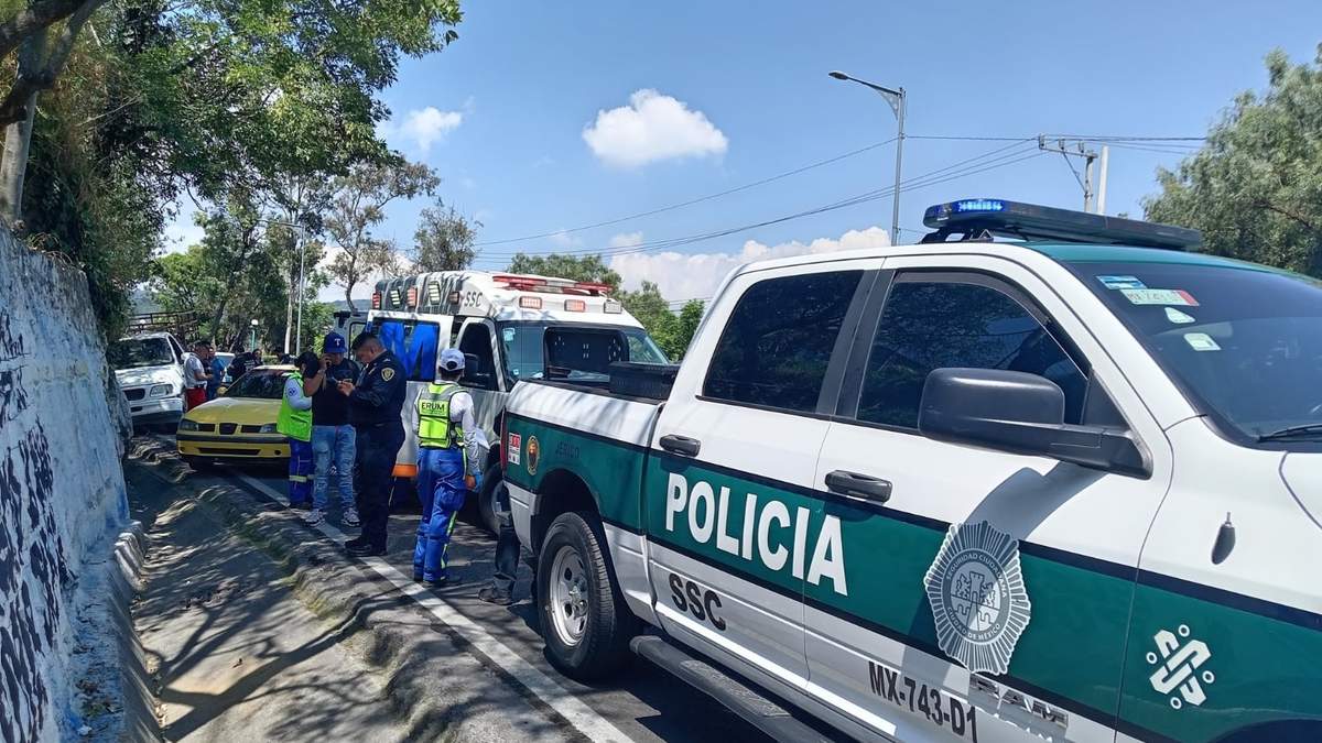 Autoridades llegan donde ocurrió el ataque armado contra dos personas en San Pedro Mártir, en la México-Cuernavaca. Al fondo se observa la camioneta blanca en la que viajaban las víctimas