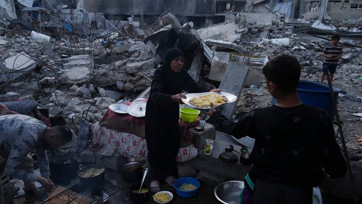 Miembros de la familia Marouf cocinan afuera de su casa, la cual fue destruida por ataques del ejército israelí, en Jabaliya, en la Franja de Gaza
