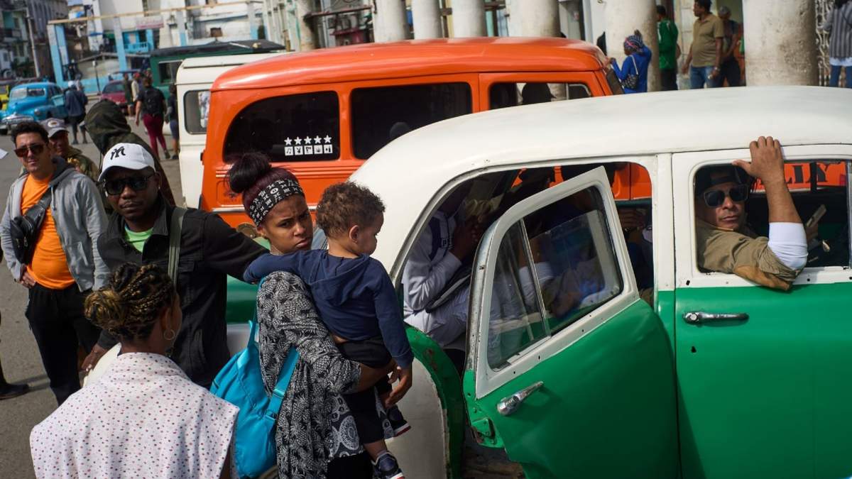 Algunas personas aguardan su turno para abordar taxis compartidos en La Habana
