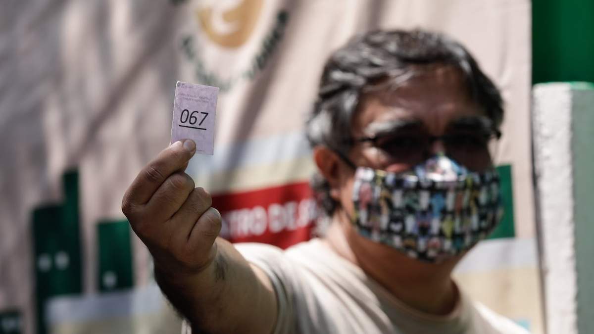 Una persona muestra su turno para realizarse una prueba de covid-19