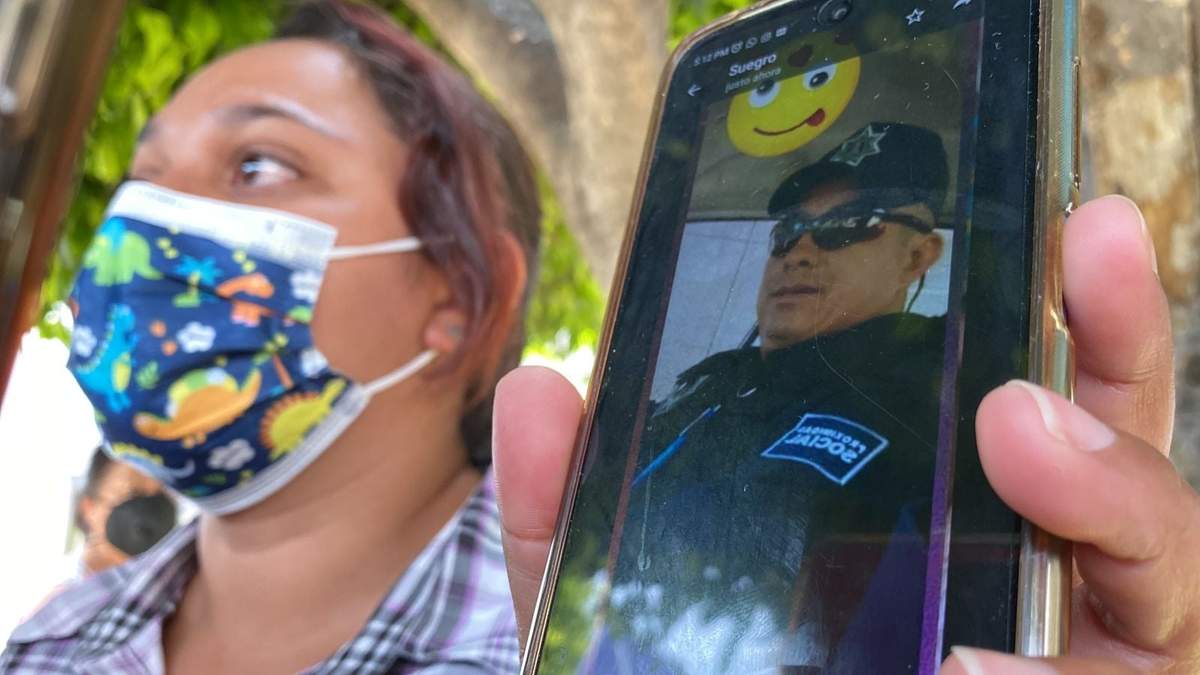 Una mujer muestra en su celular la foto del policía detenido
