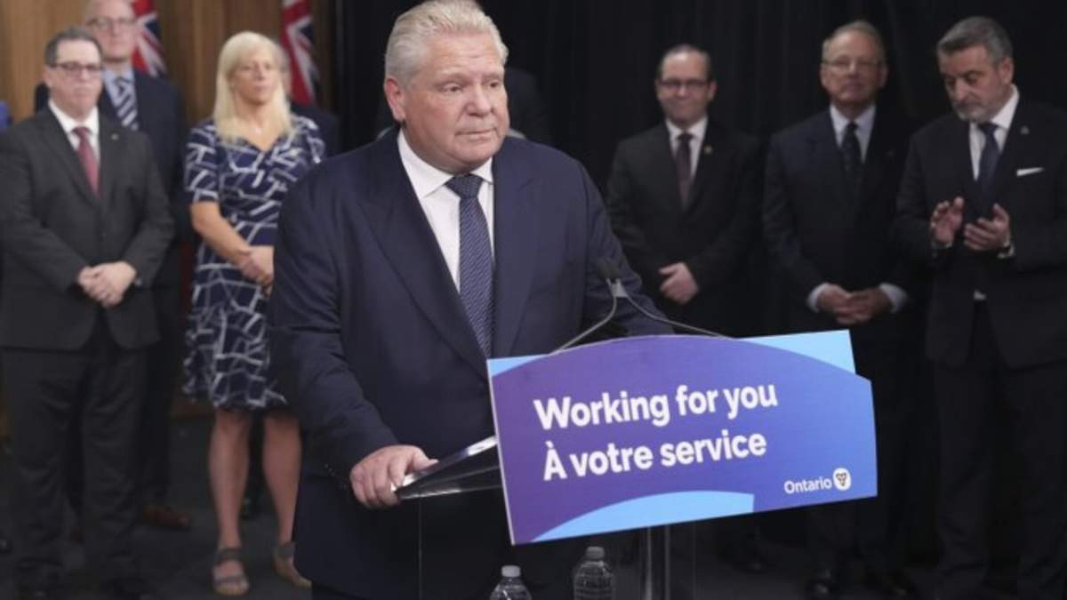 El primer ministro de Ontario, Doug Ford, habla con los medios de comunicación mientras algunos alcaldes y ministros del gobierno observan en Queen's Park en Toronto el jueves 12 de diciembre de 2024