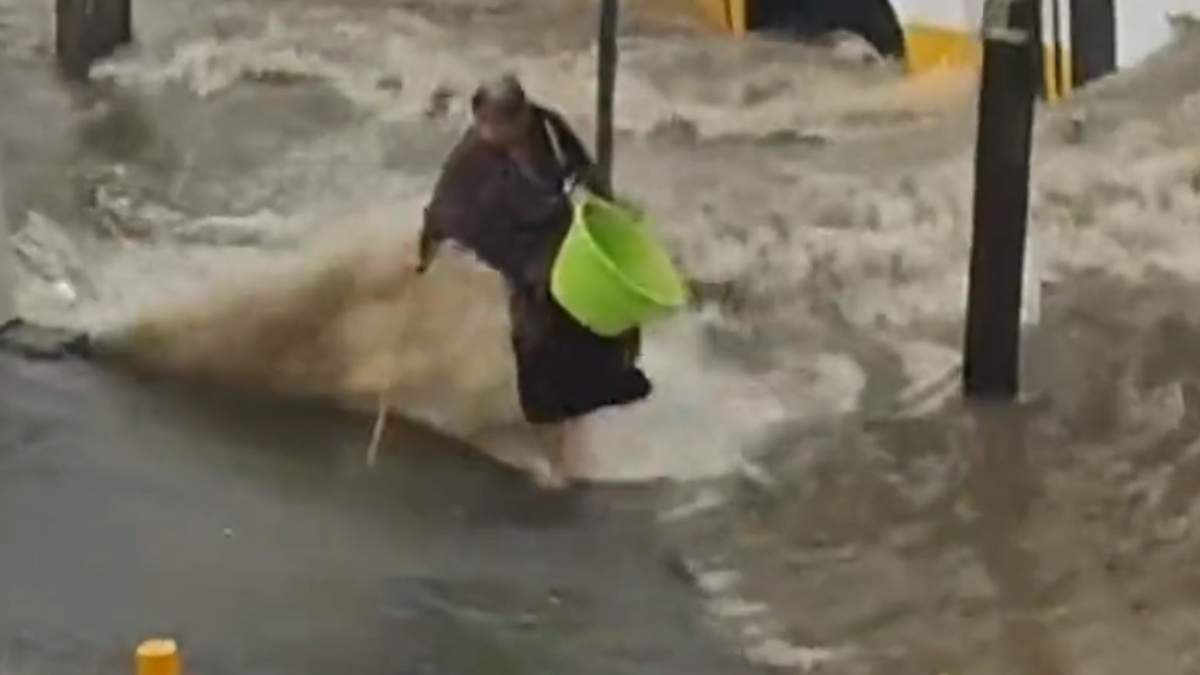 La mujer intentaba evitar el agua, pero fue alcanzada por una ola