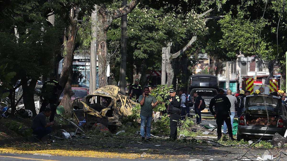 Fuerzas de seguridad inspeccionan el lugar de la explosión de una bomba en las afueras de una base de la Fuerza Aérea en Cali, Colombia