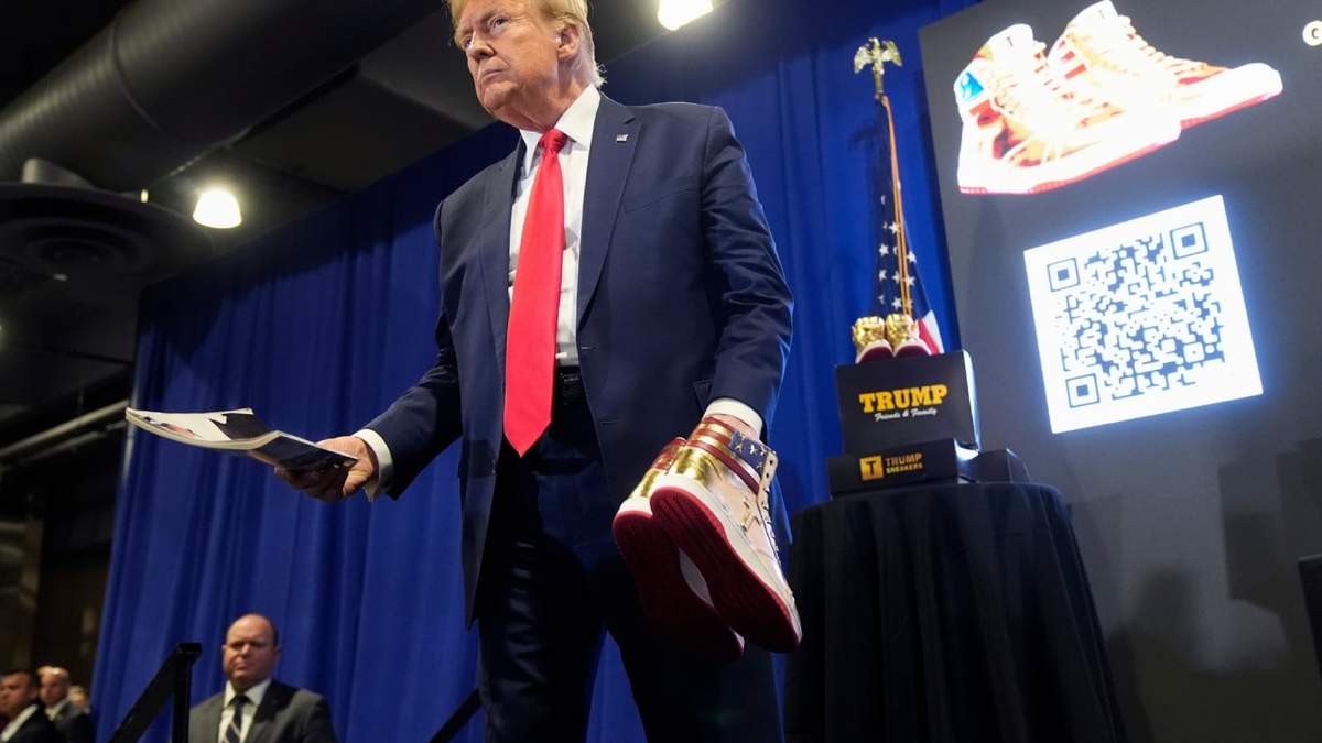 El presidente estadounidense Donald Trump presenta una revista Playboy y zapatillas doradas Trump en Sneaker Con Philadelphia, un evento popular entre coleccionistas de zapatillas, en Filadelfia, el sábado 17 de febrero de 2024