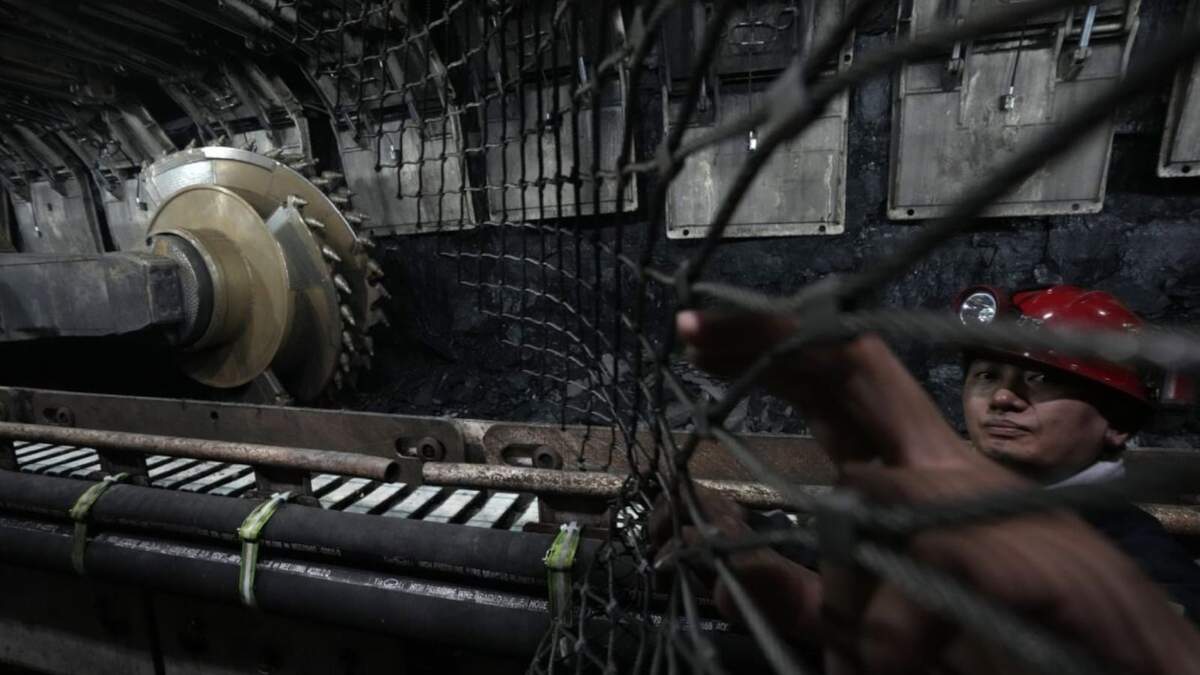 Un minero retira una cerca de metal cerca de la rozadora en la mina de carbón de Xiaobaodang, cerca de la ciudad de Shenmu, en la provincia de Shaanxi, en el noroeste de China