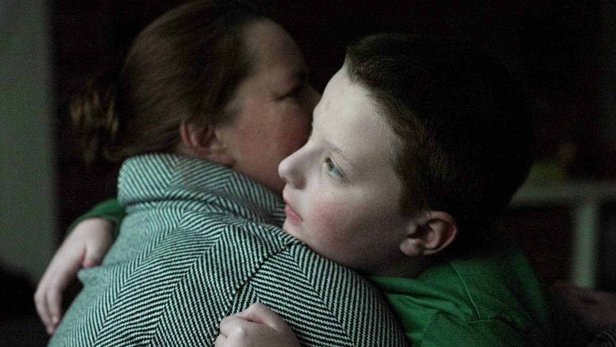 Ronan Murphy, quien padece de autismo profundo, abraza a su madre, Andrea, mientras ve la nieve caer afuera de su casa, en Ayer, Massachusetts