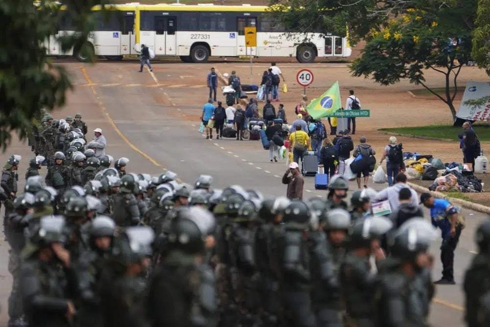 Policías toman posiciones mientras los partidarios del expresidente Jair Bolsonaro abandonan un campamento frente a la sede del Ejército en Brasil, el 9 de enero de 2023