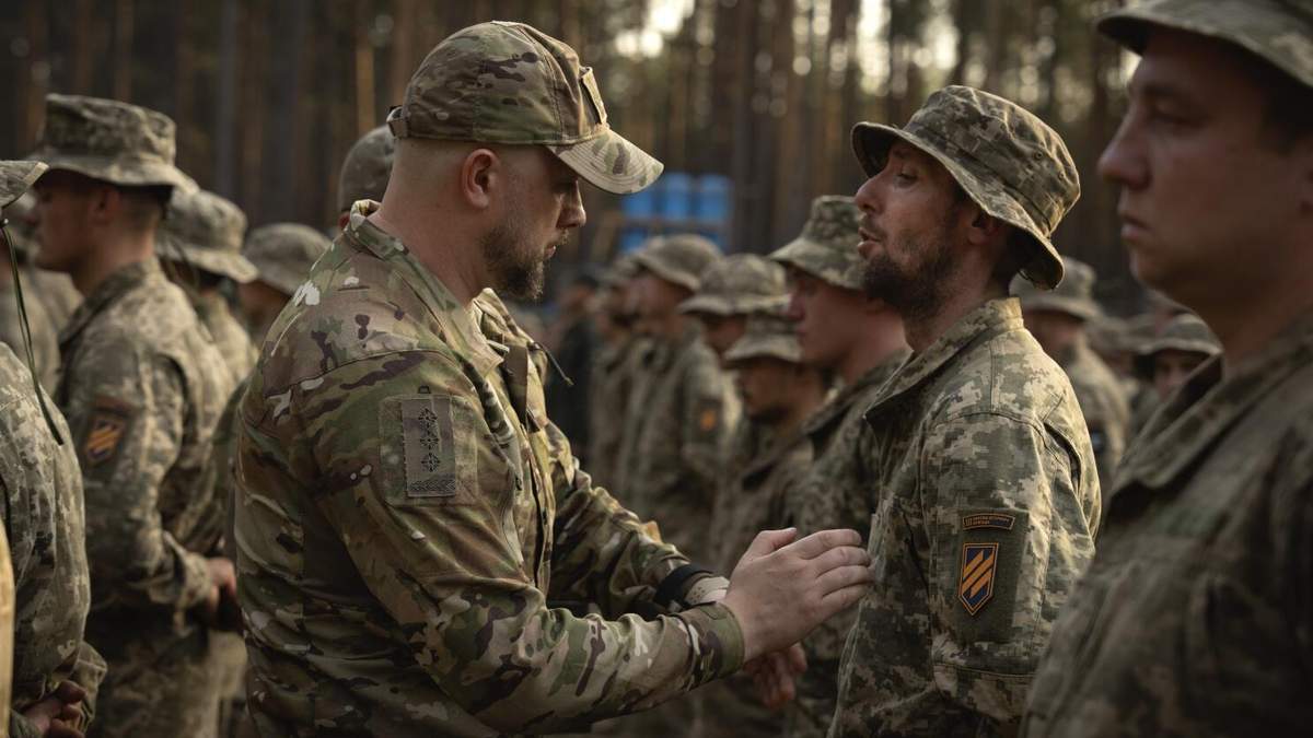 ARCHIVO - Soldados recién reclutados celebran el final de su instrucción en una base militar cerca de Kiev, Ucrania, el 25 de septiembre de 2023. Ucrania redujo el miércoles 3 de abril de 2024 la edad de reclutamiento de los 27 a los 25 años, en un intento de cubrir la falta de tropas para combatir a Rusia