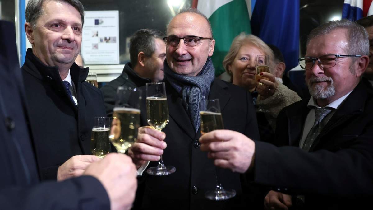 El canciller Goran Grlic-Radman (centro) brinda con el líder de la delegación húngara Peter Cseresnye (izq.), luego de levantar las puertas de cruce en la frontera en Gorican, Croacia